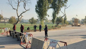 Punjab Police personnel deployed at a security checkpoint with road barriers during heightened security measures in Pakistan.