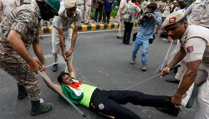 Police officers detain a student protester during the India Protest against examination paper leaks in New Delhi.