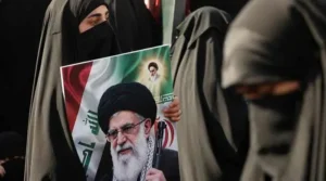 Woman holding a portrait during the Iran Funeral procession in Iraq as mourners gather for the ceremony.