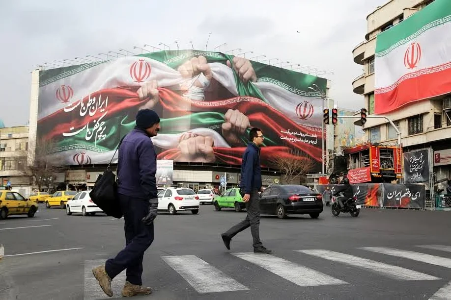 People walk past an Iranian billboard in Tehran as Iran Sanctions intensify following new US financial restrictions.