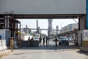 Karachi police officers and patrol vehicles standing guard at the entrance of SITE industrial area during crackdown on Karachi Extortion Network