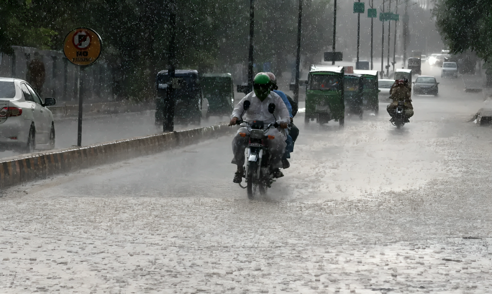 Motorcyclists and vehicles moving through heavy rain during KP Rain Deaths caused by monsoon floods in Khyber Pakhtunkhwa