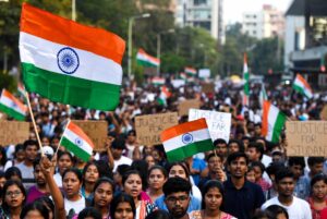 Young Indian students holding national flags and placards during a protest against the NEET paper leak in Kolkata