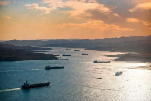 Aerial view of multiple oil tankers navigating the Strait of Hormuz at golden hour representing the potential Hormuz deal between US and Iran
