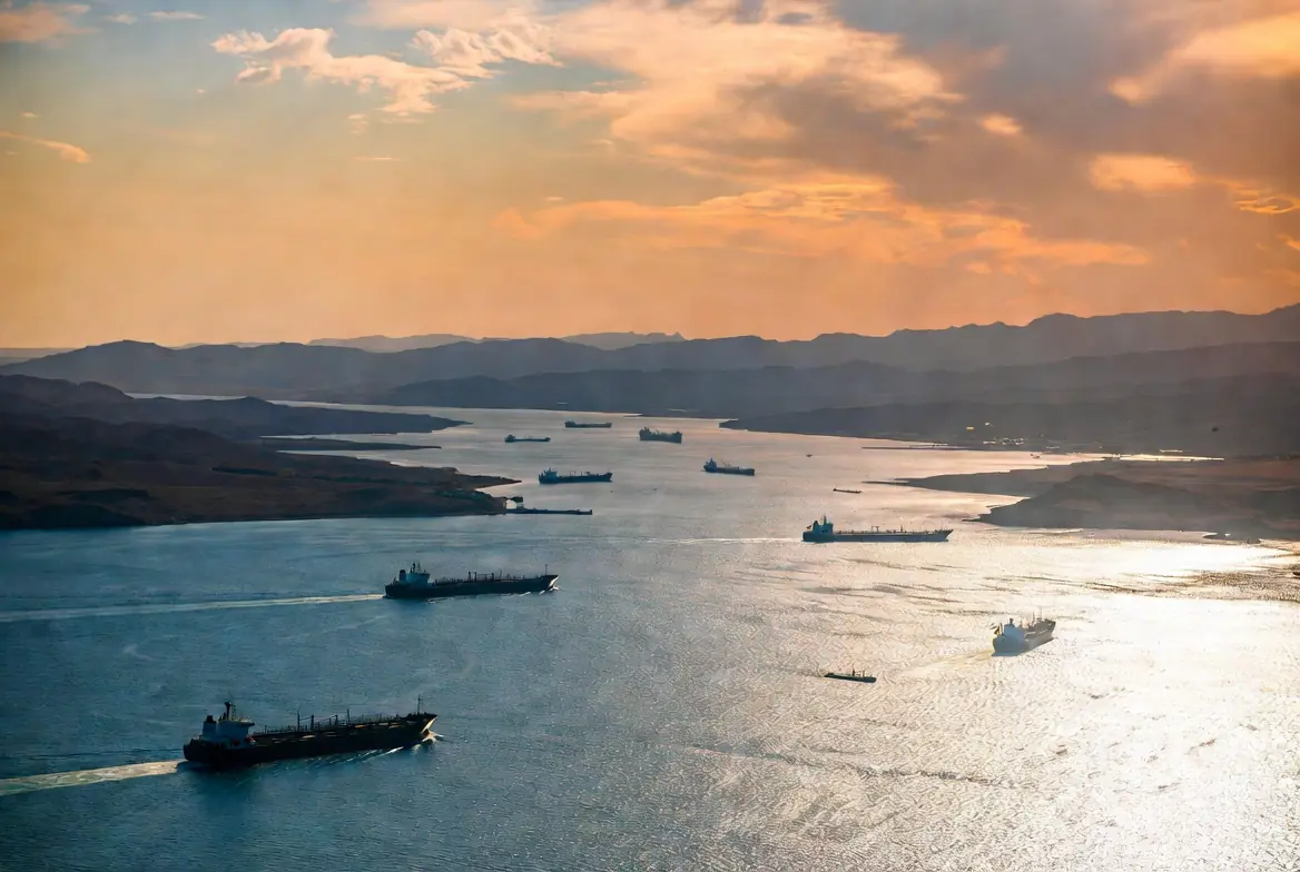 Aerial view of multiple oil tankers navigating the Strait of Hormuz at golden hour representing the potential Hormuz deal between US and Iran