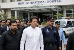 Imran Khan walking with police and security personnel outside Shifa International Hospital in Islamabad after medical examination before returning to Adiala jail