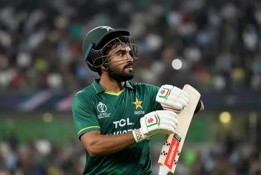 Pakistan all-rounder Khushdil Shah in green jersey holding bat during a match after dismissing quitting Pakistan cricket rumours
