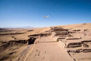 Aerial view of Nazca Lines desert geoglyphs with a small tourist plane flying overhead related to the Nazca plane crash