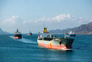 Large oil tankers sailing through the calm waters of the Strait of Hormuz amid rising oil price concerns