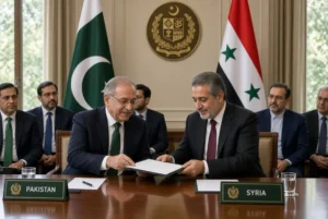 Pakistani and Syrian foreign ministers exchanging official documents during Syrian FM visit to Islamabad with both national flags in the background