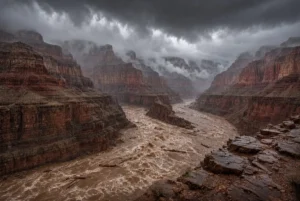 Dramatic view of Grand Canyon floods with muddy river rushing through red rock cliffs under dark monsoon storm clouds and heavy rain