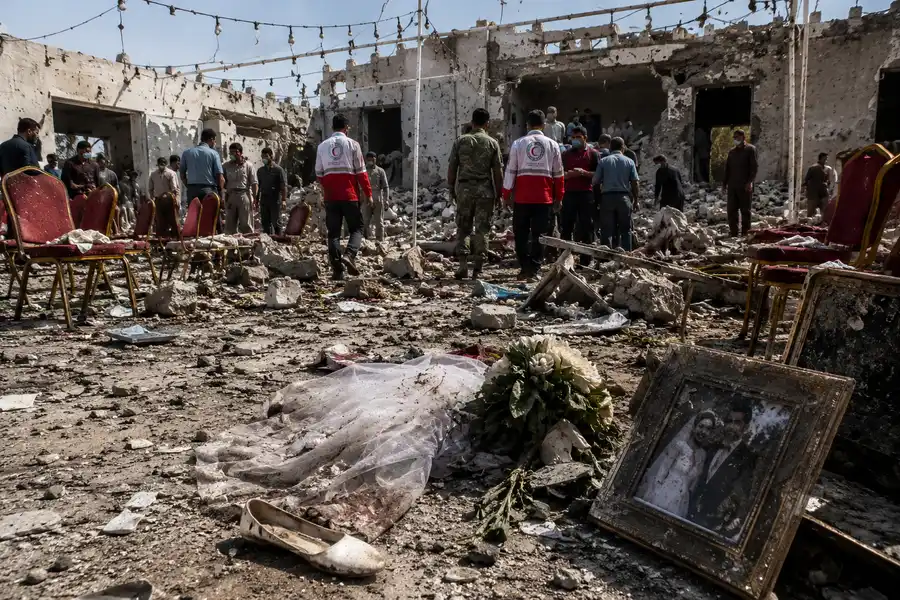 Aftermath of Iran wedding strike in Sirik with damaged wedding venue and rescue workers