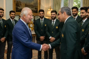 King Charles III in a blue pinstripe suit shaking hands with Pakistan Cricket Board Chairman Mohsin Naqvi in a green blazer with gold star emblem, while smiling Pakistan national cricket team players in formal green jackets stand in the background at Clarence House, London.
