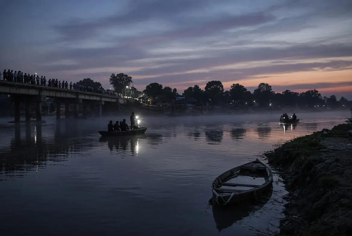 Rescue personnel searching the Ganges river after Bihar boat tragedy with villagers watching from the bridge at dusk