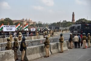Police in riot gear standing behind barricades during Delhi protest lockdown as thousands detained over election voter list controversy