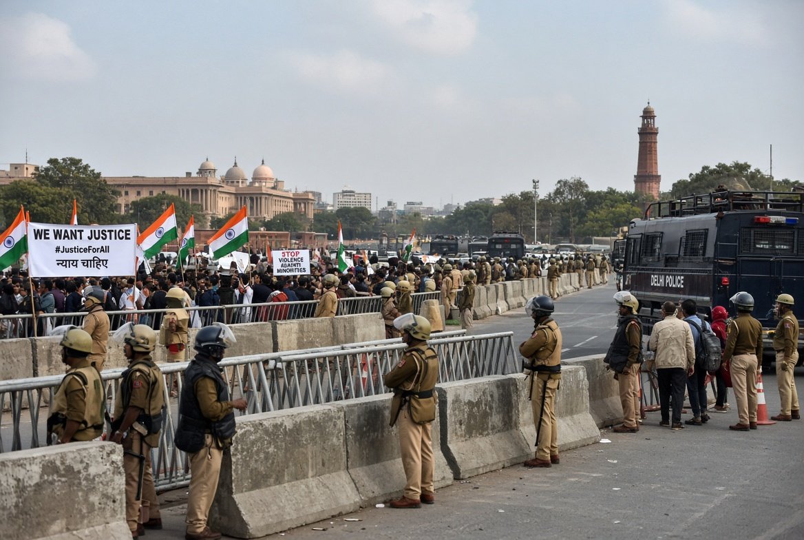 Police in riot gear standing behind barricades during Delhi protest lockdown as thousands detained over election voter list controversy