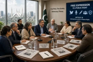 Senior journalists and civil society members discussing freedom of expression at a roundtable meeting in Islamabad Pakistan with Pakistani flag and press freedom banners