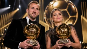 Harry Kane and Alexia Putellas holding golden football trophies at an awards ceremony, representing the Harry Kane Ballon d'Or victory in 2026.