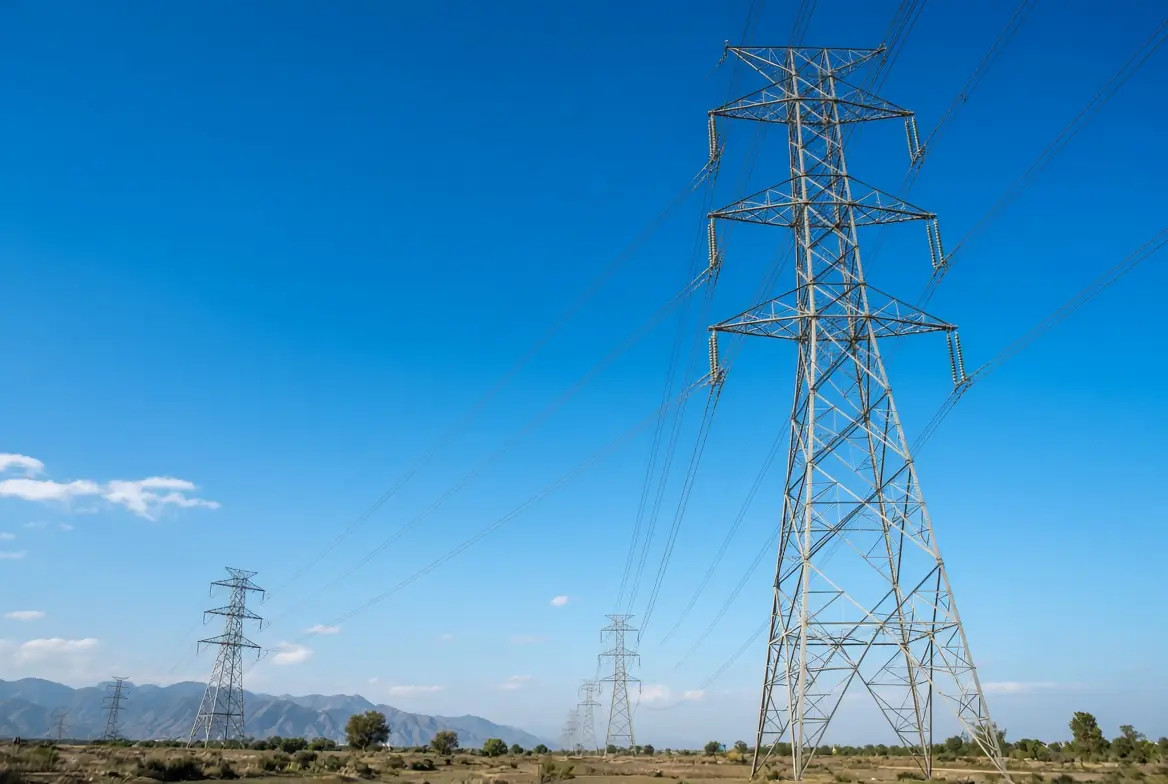High voltage electricity transmission pylons and power lines under clear blue sky related to higher electricity charges reforms