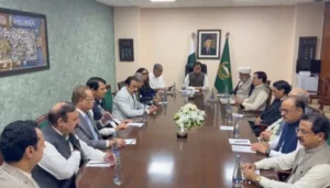 Political leaders seated around a conference table during PTI talks with the government in the National Assembly speaker’s chamber