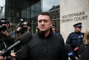 Tommy Robinson standing outside Southwark Crown Court surrounded by media after being convicted of harassing two journalists