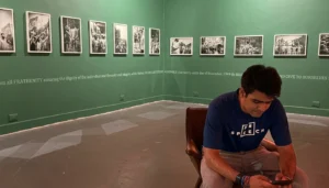 Raihan Vadra sitting among paintings after being forced to remove Vadra protest artwork from Delhi exhibition